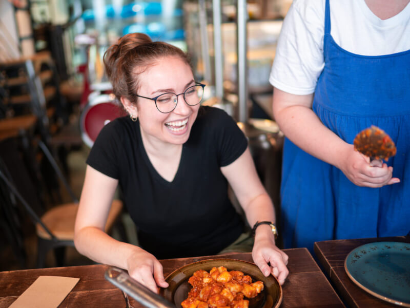 woman smiling with plate of gnocchi